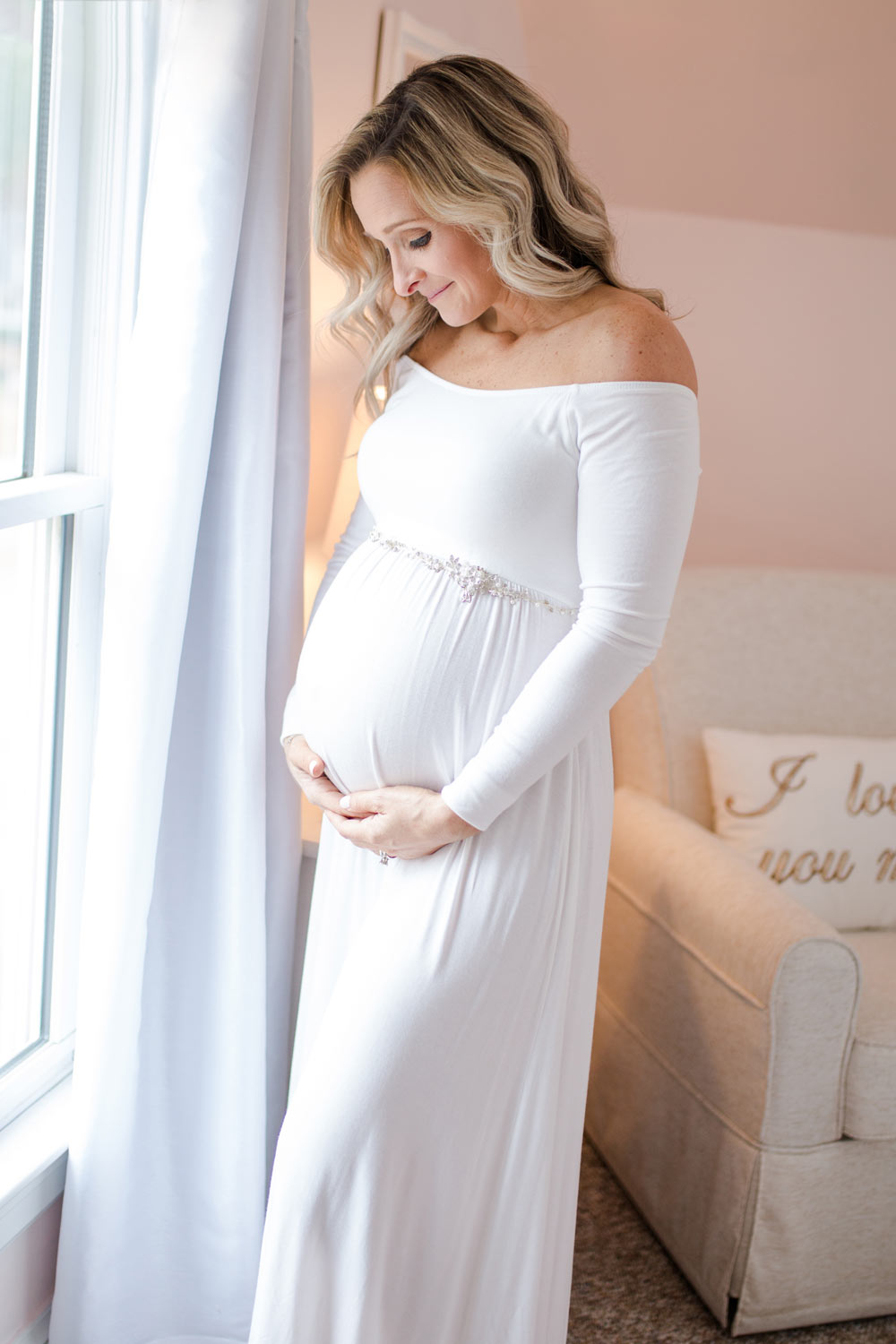 Beautiful Mother to be with a baby bump and white maternity dress